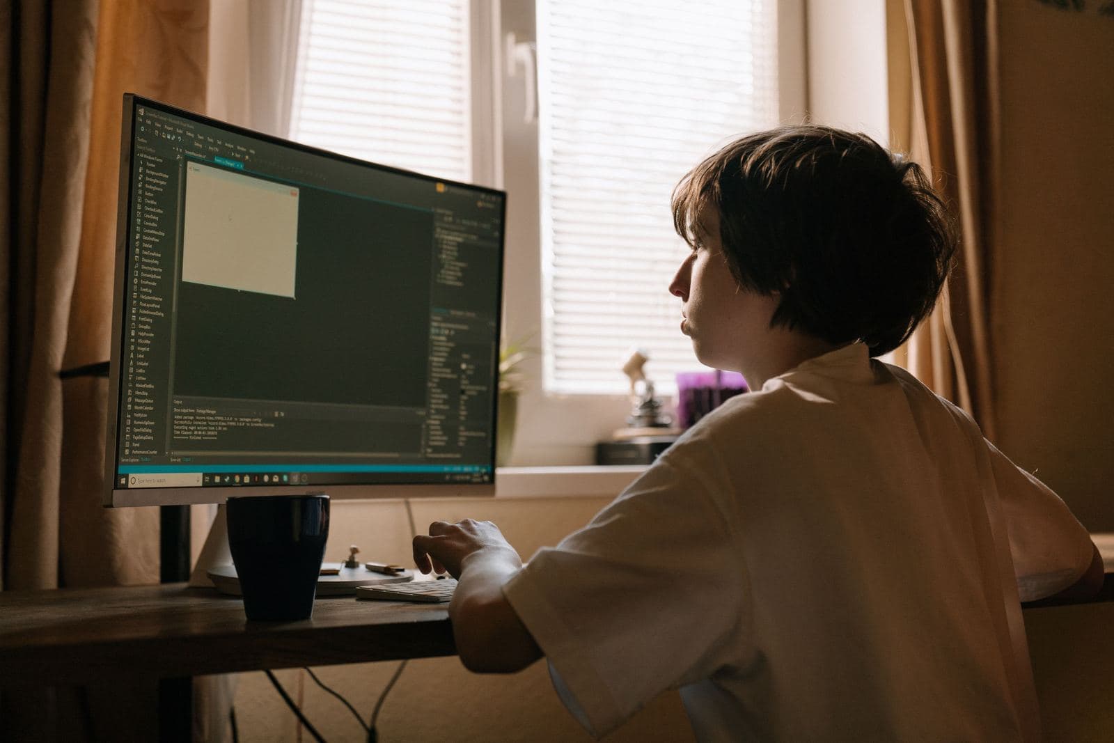A kid sitting at a computer learning to code