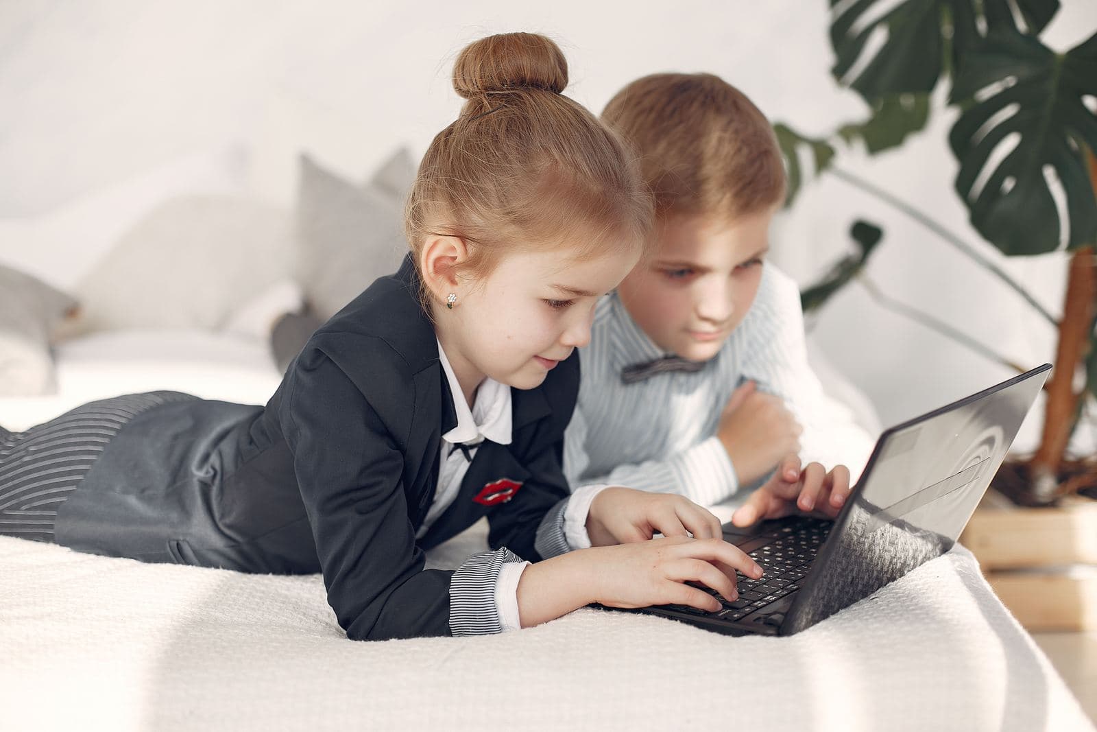 Two kids working together on a laptop