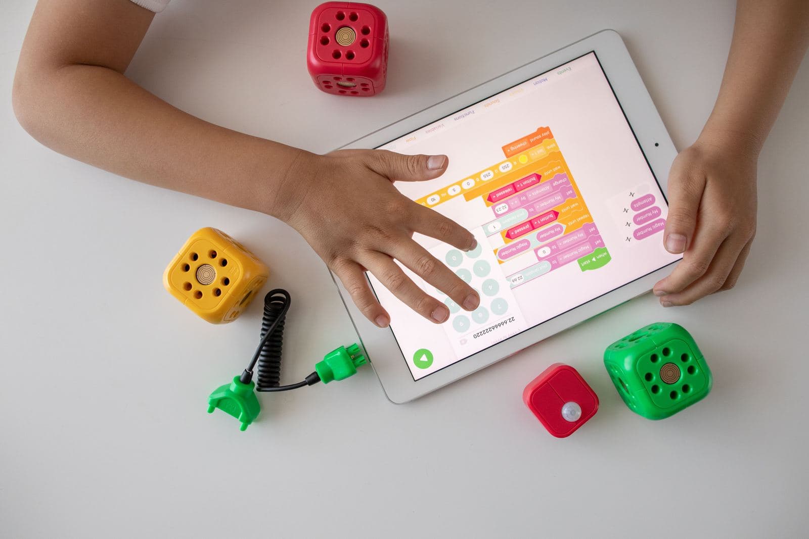 A kid arranging colorful code blocks on a tablet